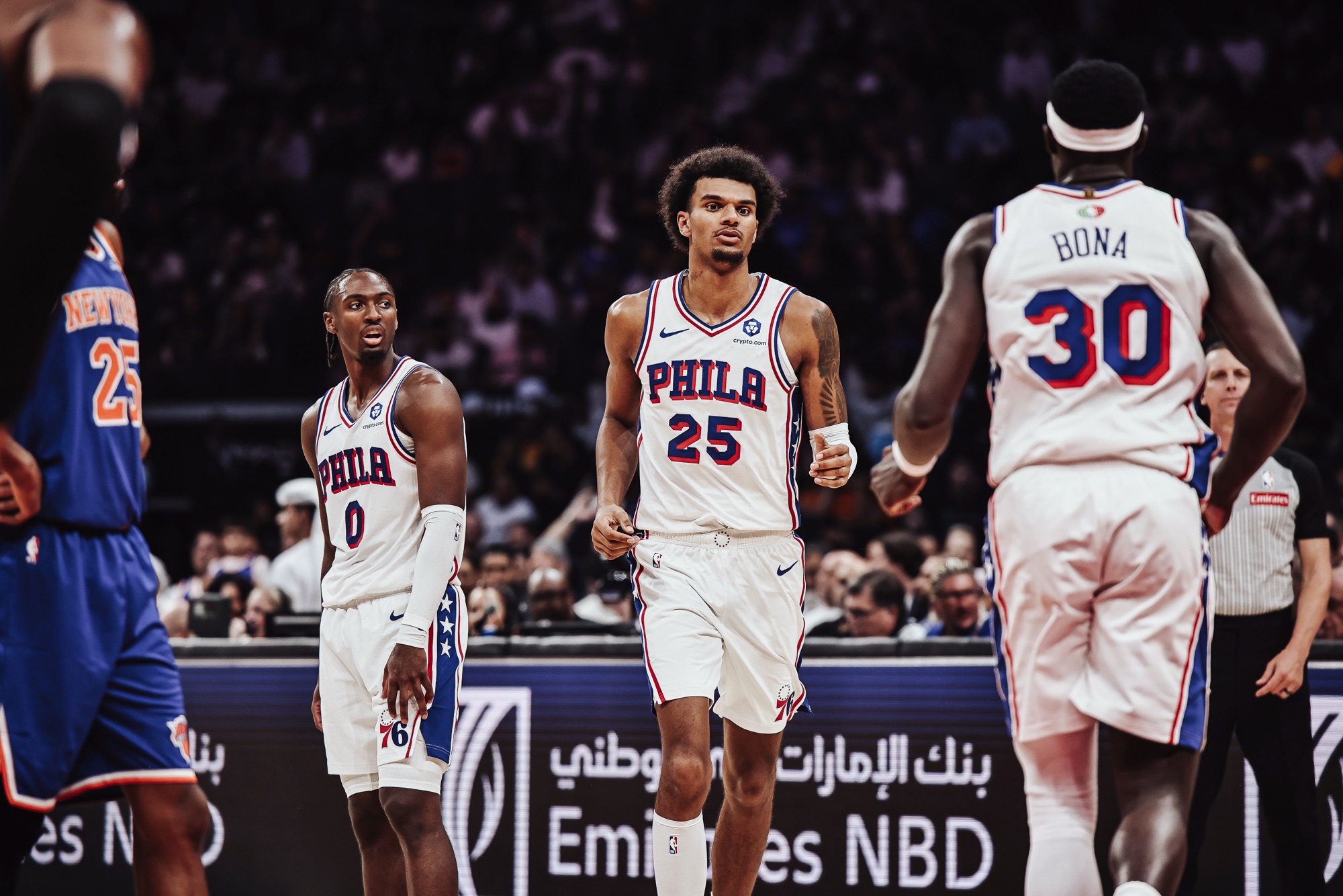 Philadelphia 76ers players in white jerseys on court during a game against New York