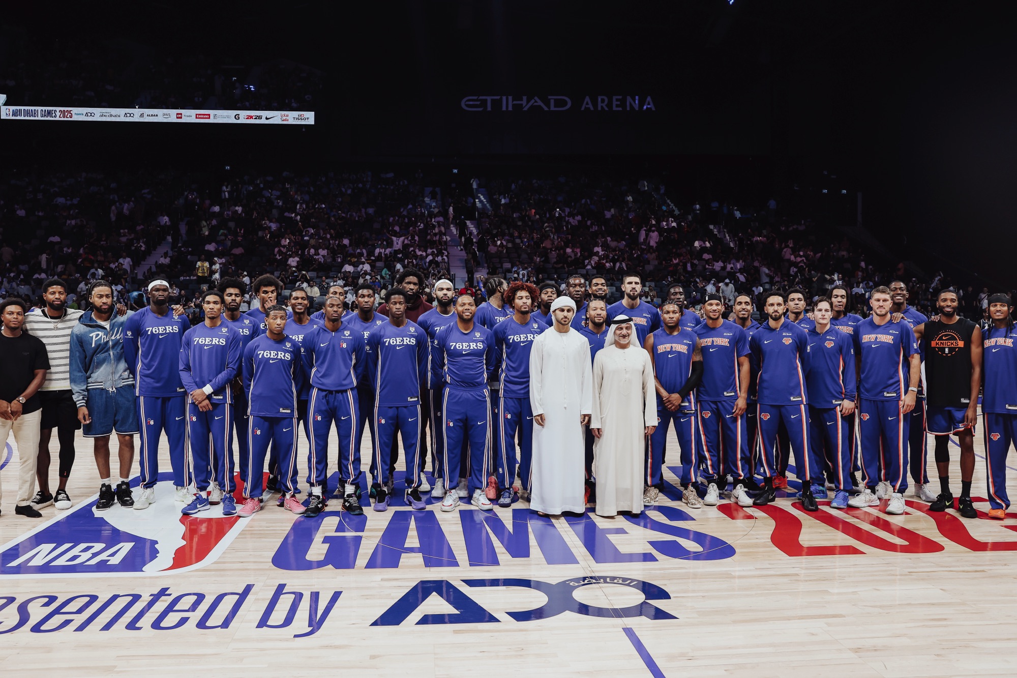 76ers and Knicks squads lined up together on the NBA Abu Dhabi Games court at Etihad Arena