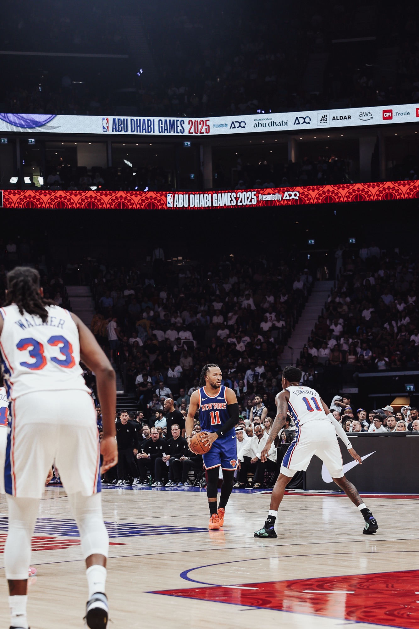 Player in a New York No. 11 jersey bringing the ball up against Philadelphia defenders