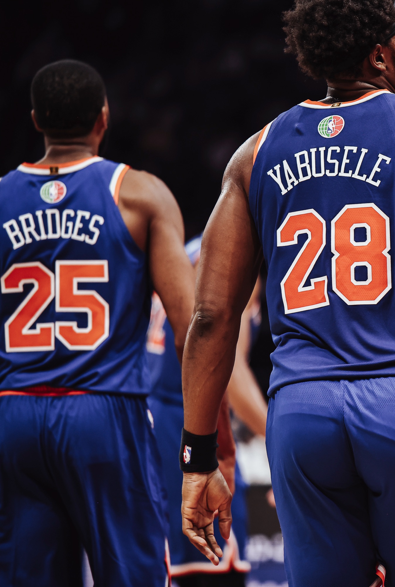 Two New York players in No. 25 and No. 28 jerseys seen from behind, close-up
