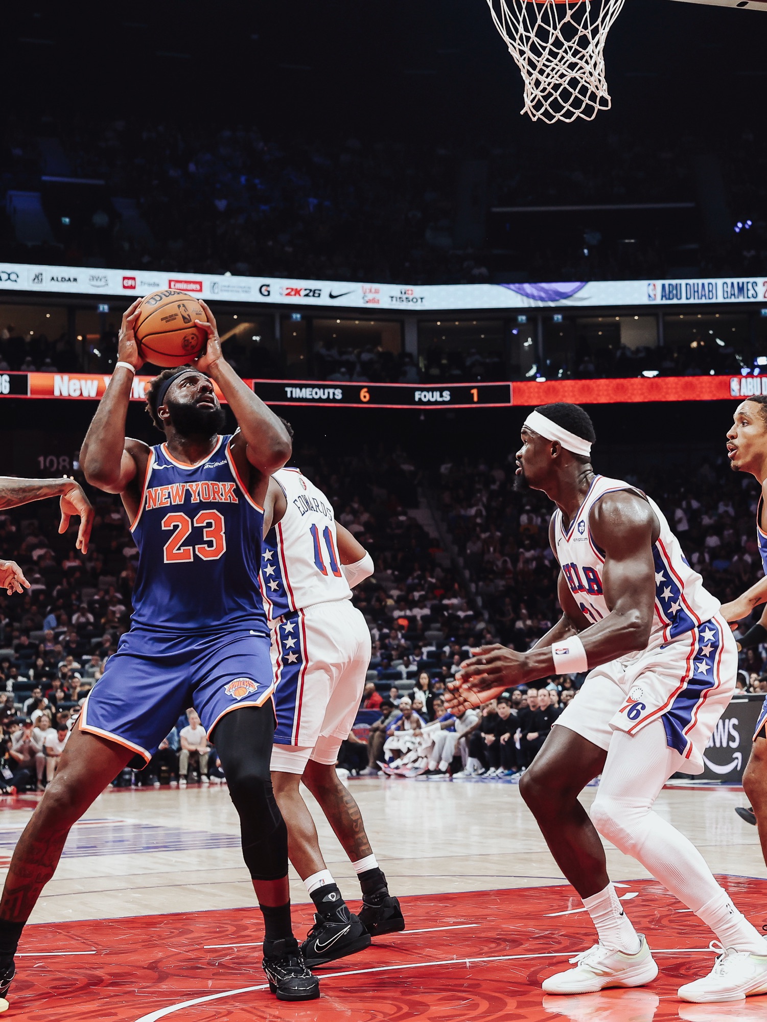 New York No. 23 going up for a shot under the basket against Philadelphia defenders
