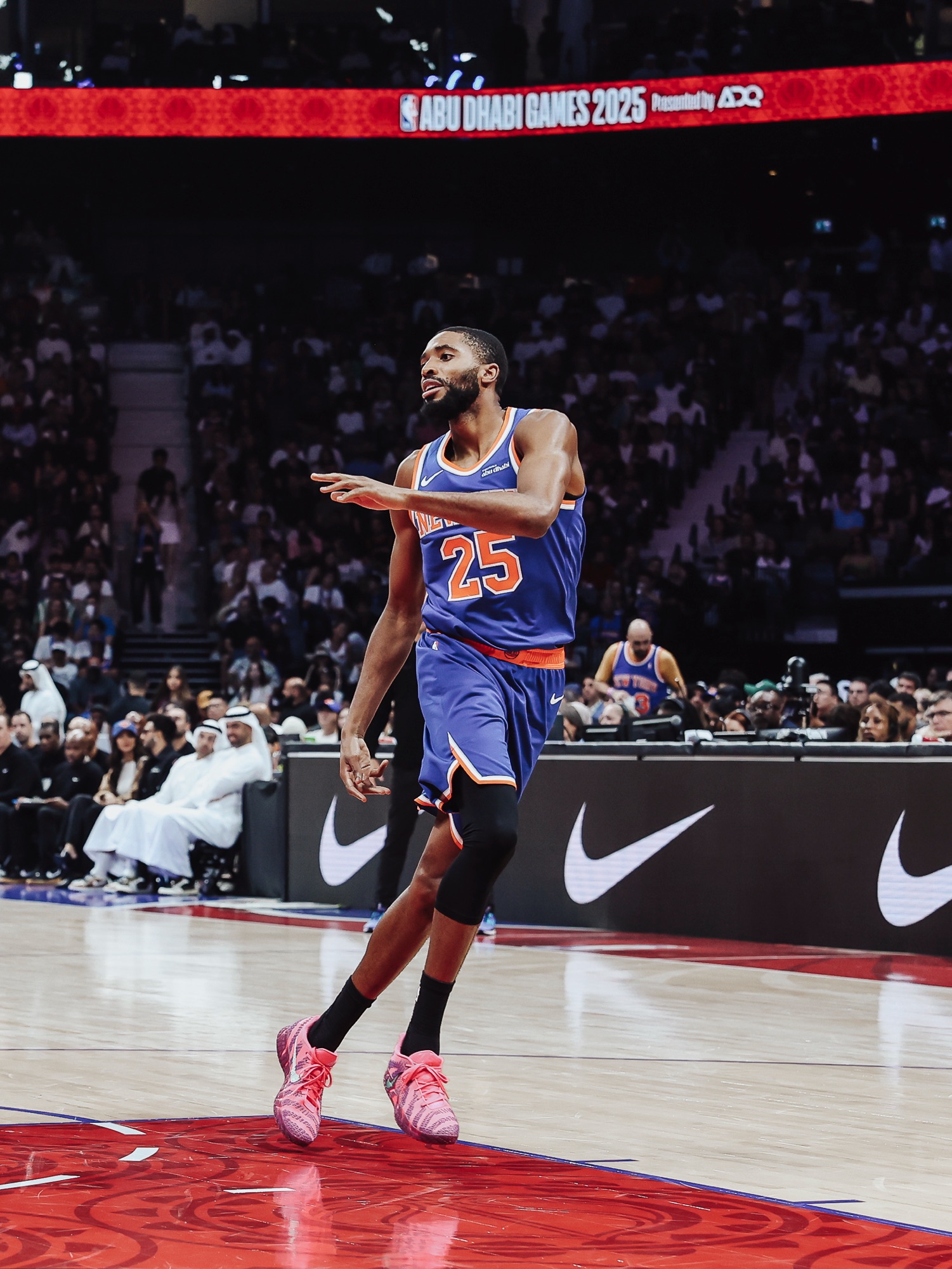 Player in a blue New York No. 25 jersey pointing during play in pink sneakers