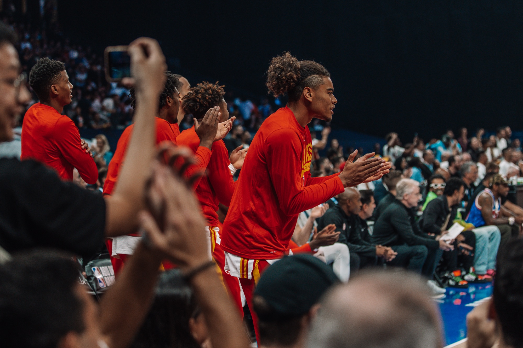 Atlanta players in red warm-ups clapping and cheering from the sideline