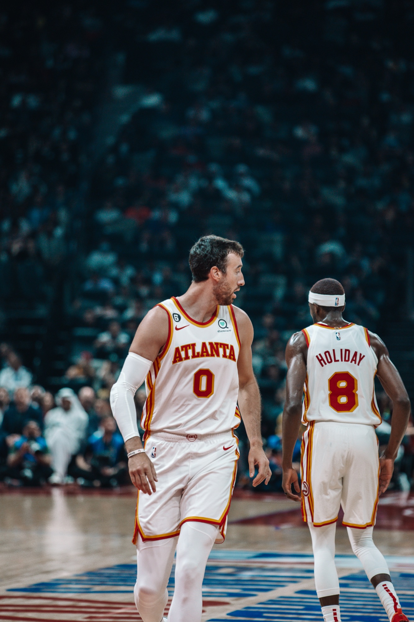Atlanta No. 0 and No. 8 in white jerseys looking downcourt during a game