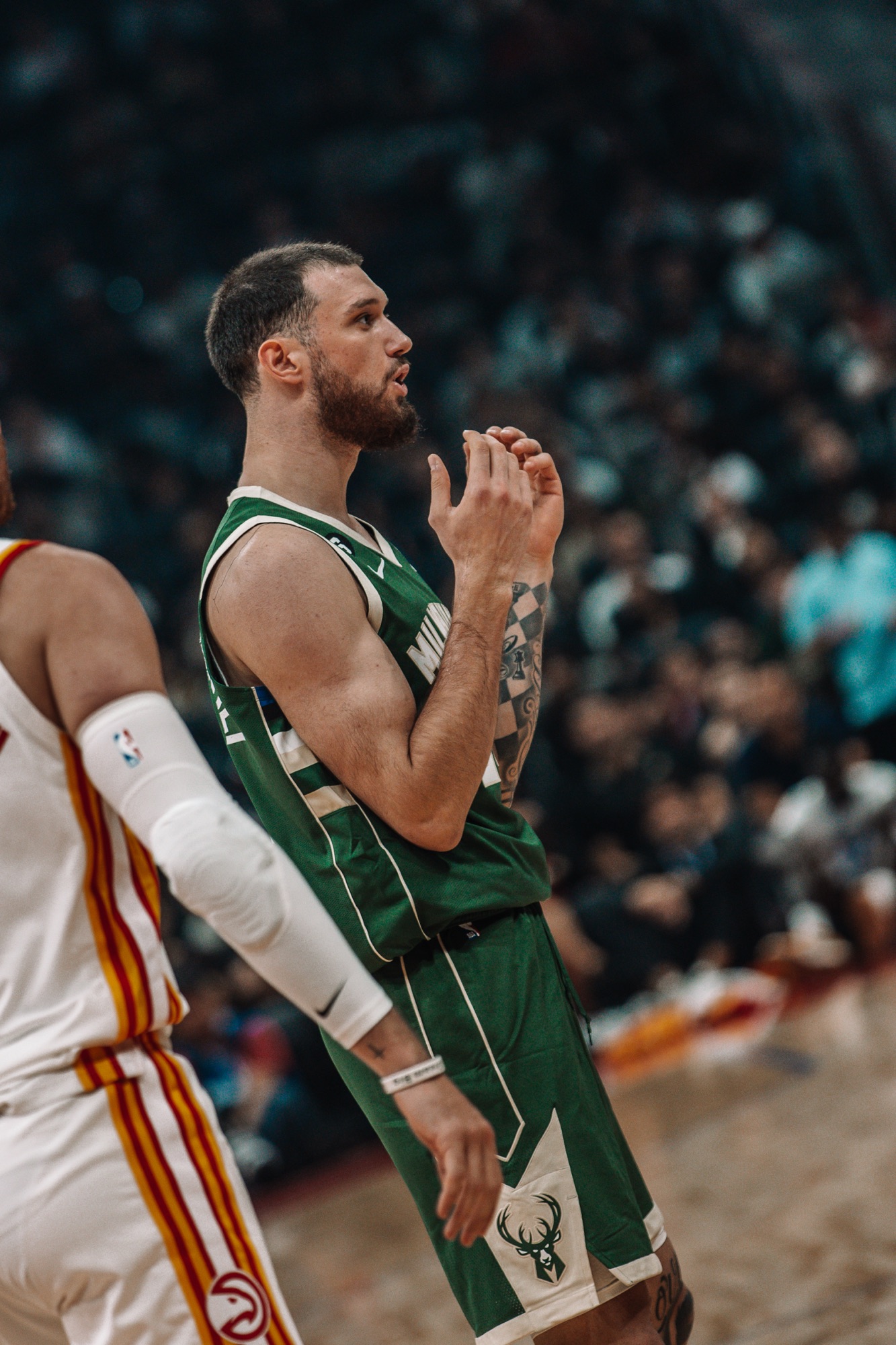 Player in a green Milwaukee jersey gesturing during a game, close-up