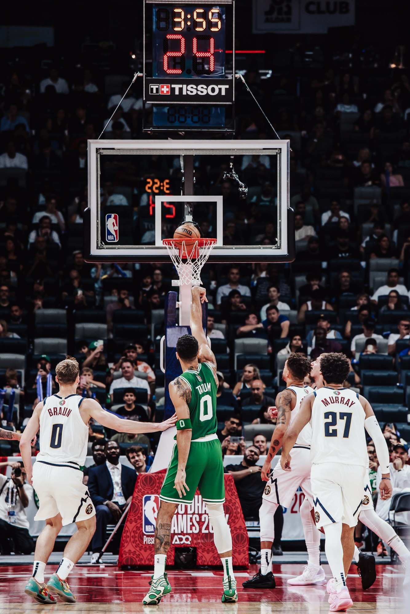 Boston No. 0 tipping the ball at the rim as Denver players box out