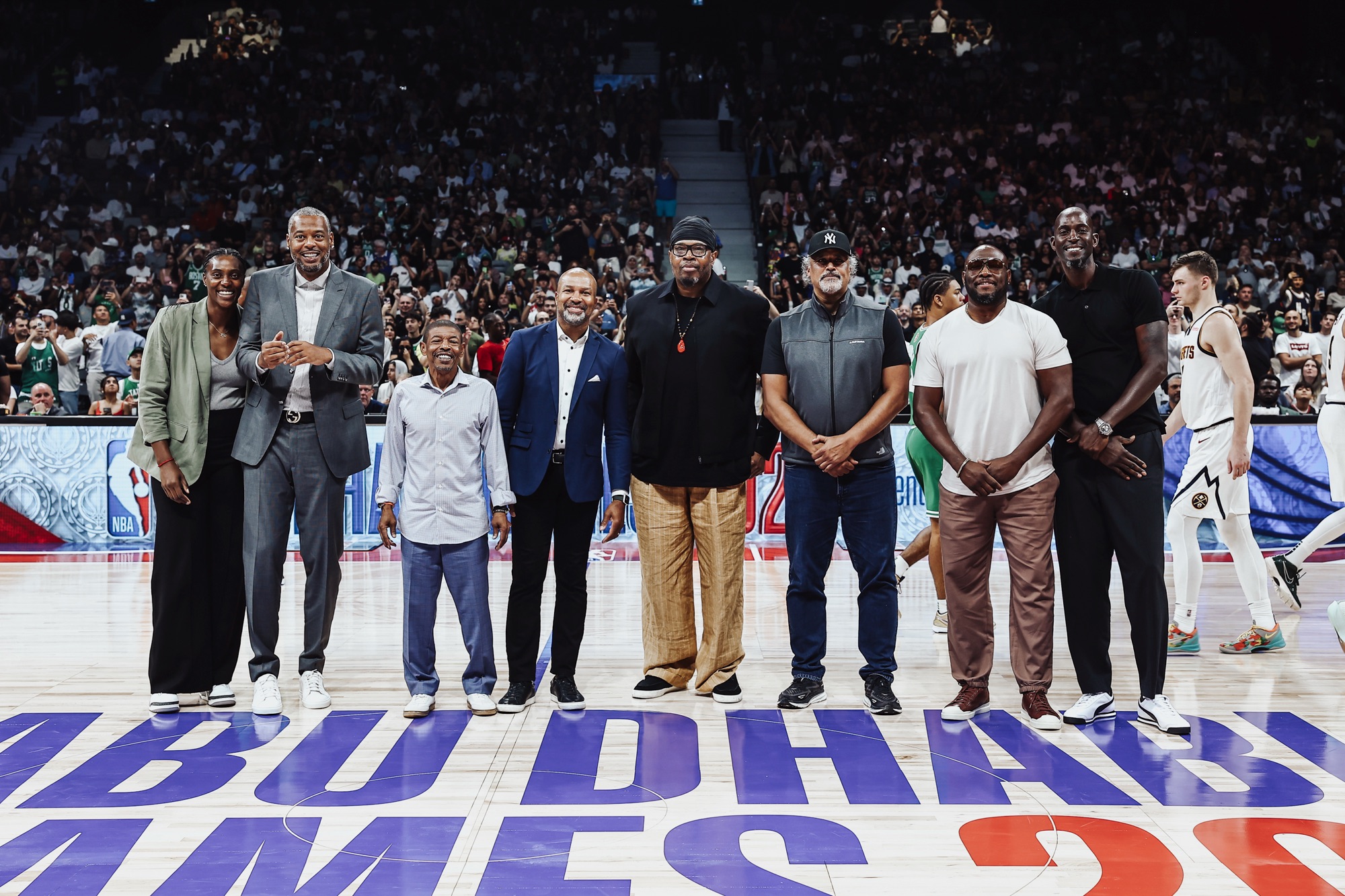 Group of former players and guests posing at centre court during a game break