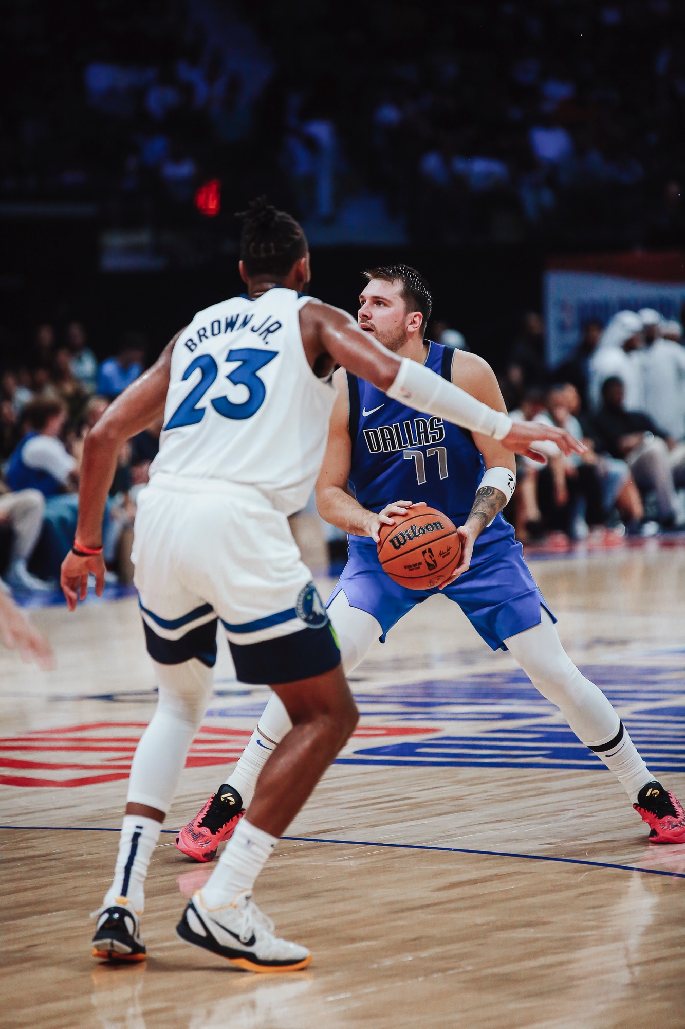 Player in a Dallas No. 77 jersey holding the ball as a Wolves defender closes in