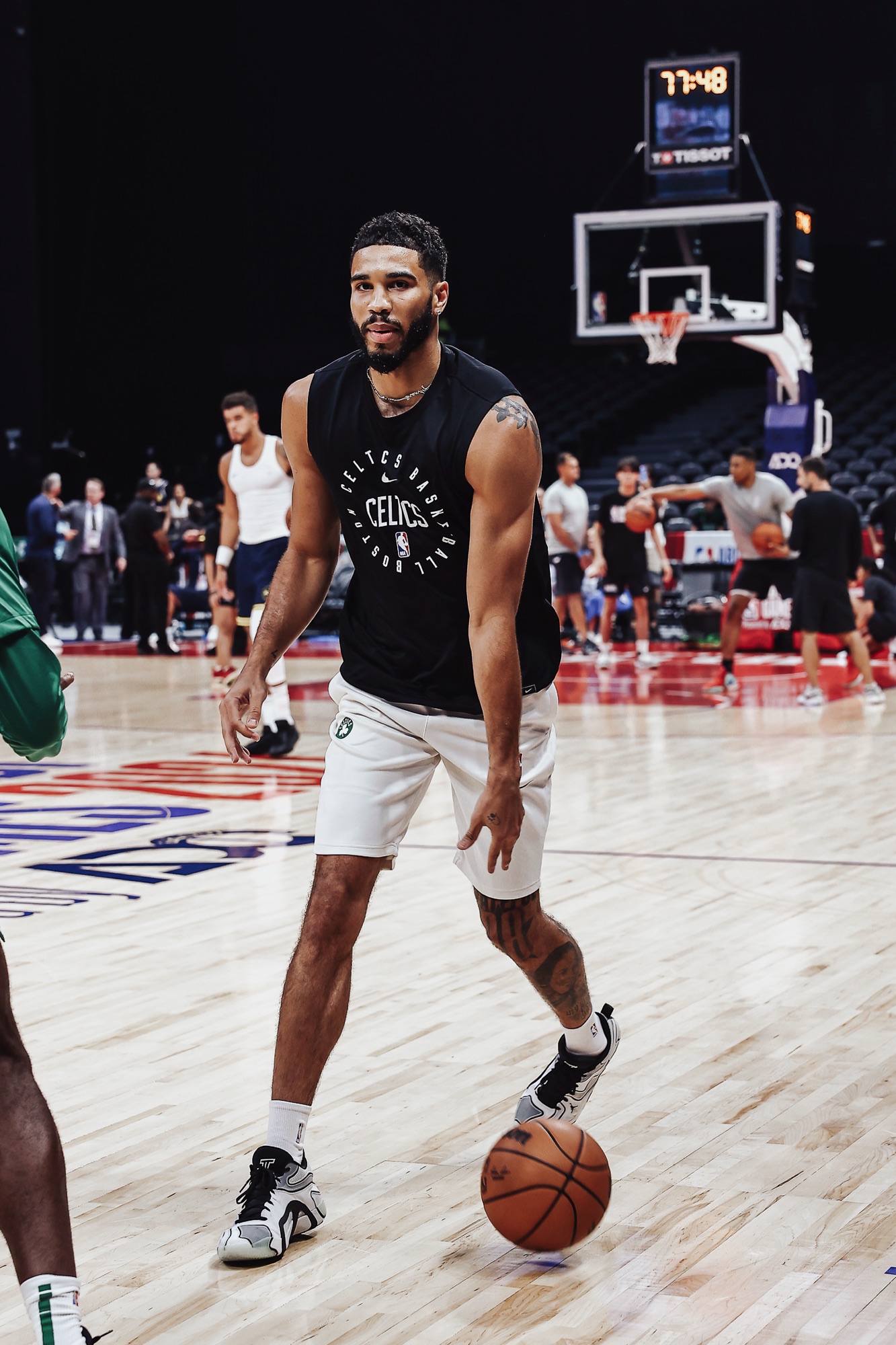 Player in a black Celtics sleeveless top dribbling during pre-game warm-ups