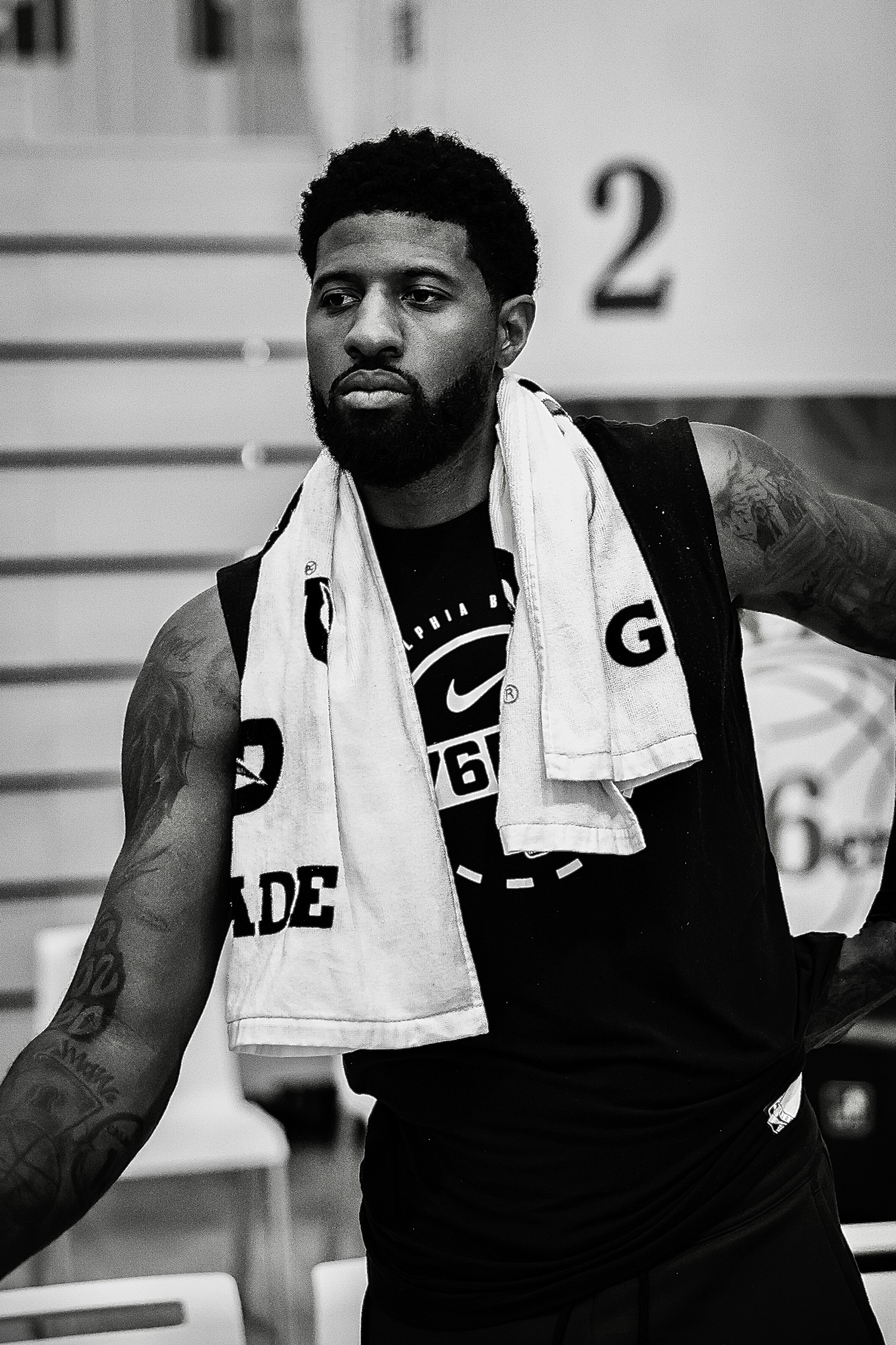 Black-and-white portrait of a player with a towel around his neck at practice