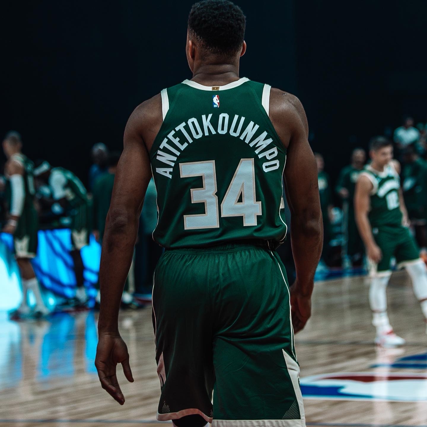 Player in a green number 34 jersey seen from behind on court