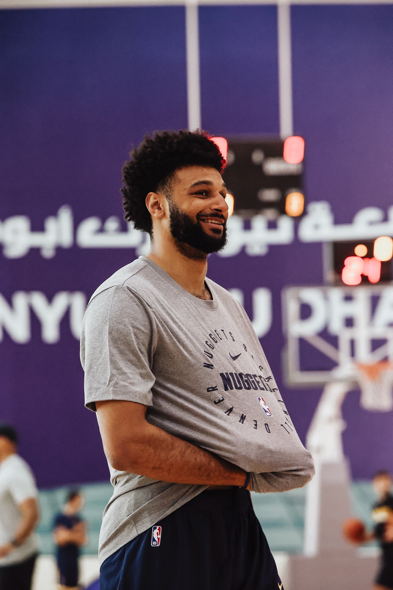 Smiling player in a grey Nuggets T-shirt at practice in the NYU Abu Dhabi gym