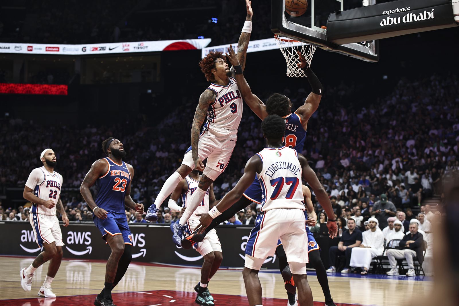 Player rising for a dunk over defenders during an arena game