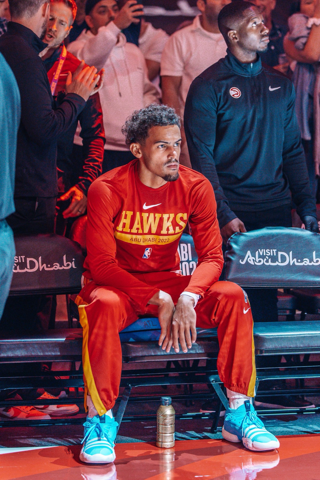 Player in a red Hawks warm-up seated courtside